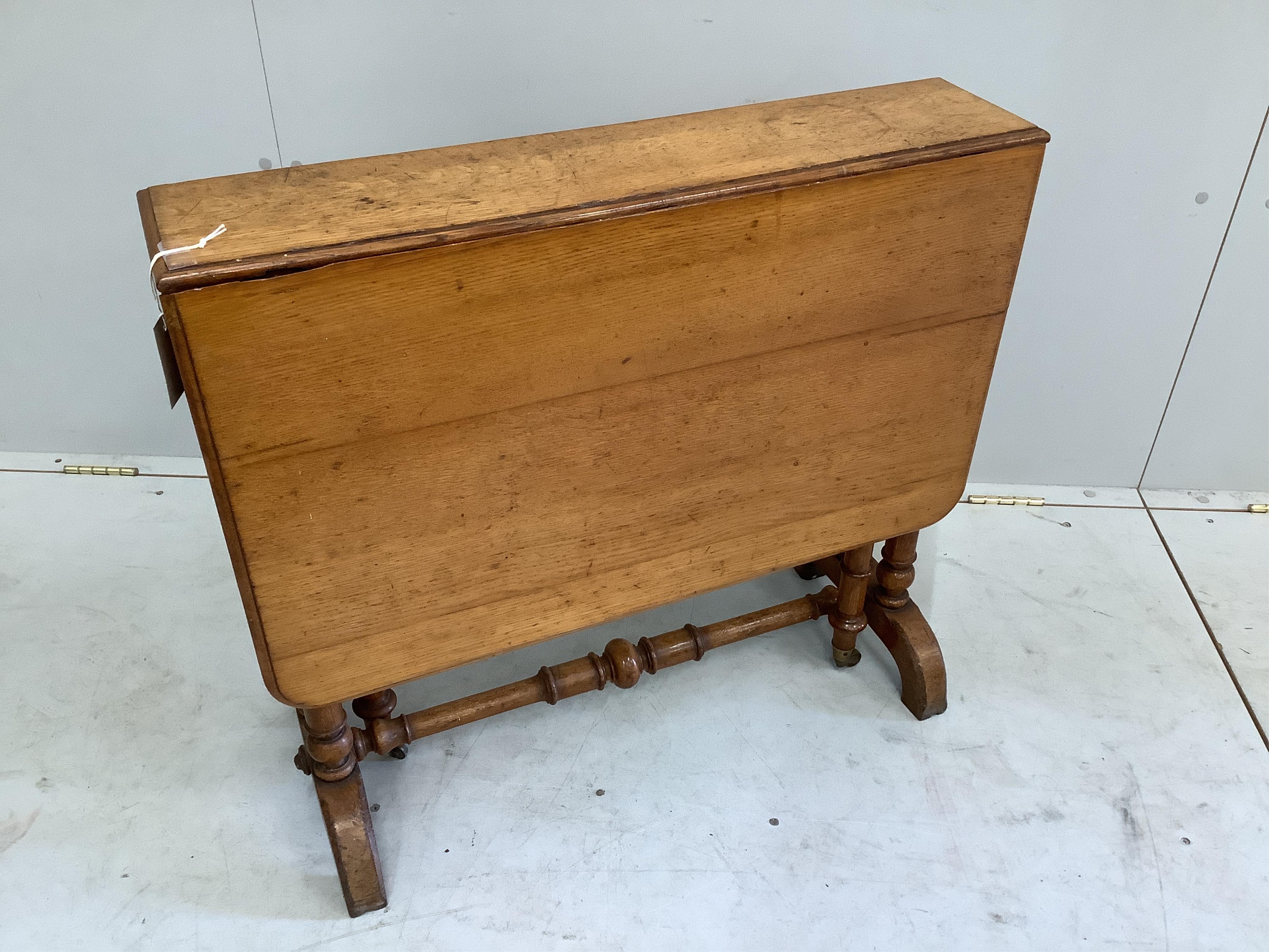 A late Victorian Howard and Sons oak Sutherland table, width 76cm, depth 18cm, height 68cm. Condition - fair